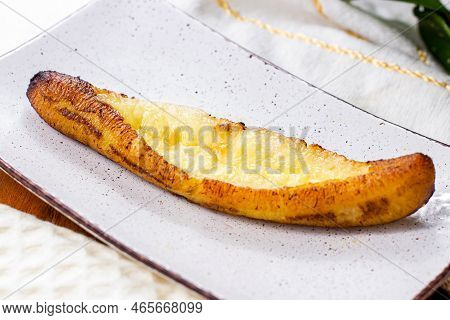 Baked Ripe Plantains With Cheese (plantain Canoe Or Platanos Asados Con Queso) On A Plate On Wooden 