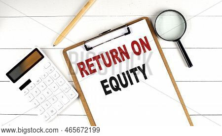 Return On Equity Words On Clipboard, With Calculator, Magnifier And Pencil On White Wooden Backgroun