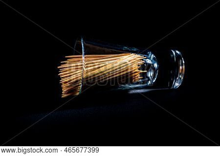 Bamboo Wooden Toothpicks In Glass Jar, Wine Glass. In Bucket. Toothpicks On Black Background. Front