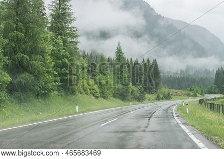 Rainy Road Surface And Raindrops On A Car Windshield