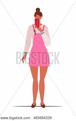 Young Modern European Girl In A Pink Dress With A Phone In Her Hand. Isolated On White Background.