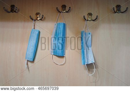 Close-up View Of Coat Rack With Three Medical Masks Are Hanging On Wooden Wall. Antivirus (coronavir
