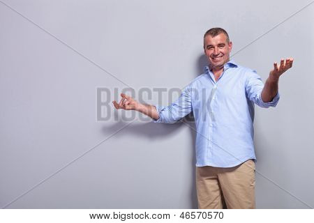 lässig senior Man Sie mit einem Lächeln begrüßen. auf grauem Hintergrund