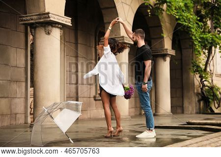 Young Couple Dancing Under Rain On City Street