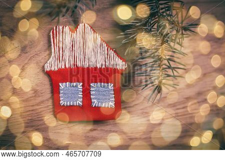 Concept Of Christmas.knitted House And Pine Branch On Wooden Bac