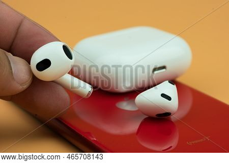 Bangkok, Thailand - November 19, 2022 : Man Hand Holding Apple Airpods 3 With Red Iphone. Close Up
