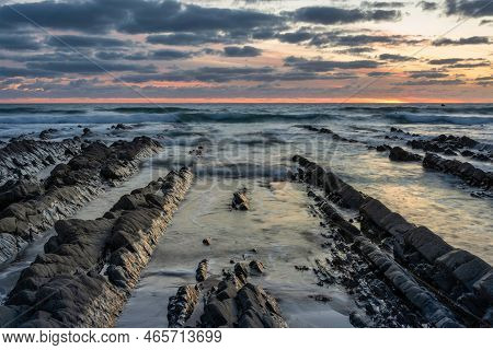 Stunning Sunset Landscape Image Of Welcome Mouth Beach In Devon England With Beautiful Rock Formatio
