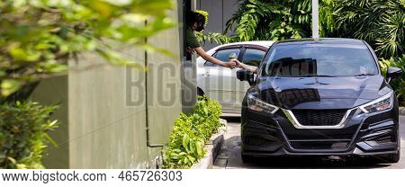 Hand Man In Car Receiving Coffee In Drive Thru Fast Food Restaurant. Staff Serving Takeaway Order Fo