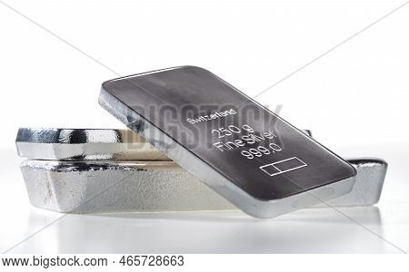 Minted Silver Bar Weighing 250 Grams Against A Background Of A Stack Of Various Silver Ingots. Isola