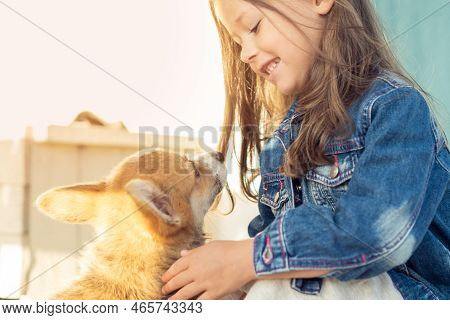 Side View Of Smiling Little Girl With Long Dark Hair Wearing Denim Jacket, Looking At Wonderful Wels