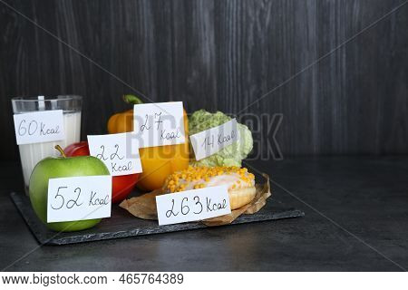 Food Products With Calorific Value Tags On Black Table, Space For Text. Weight Loss Concept