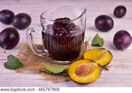 Plum Jam In A Glass Gravy Boat On A Berm Wooden Background.