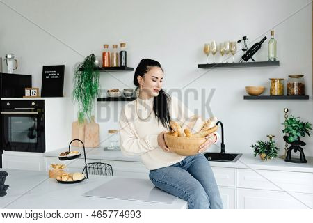 A Woman Sits In Her Kitchen Holding A Bread Basket. Enjoying The Little Things. Lykke Concepts. Rela