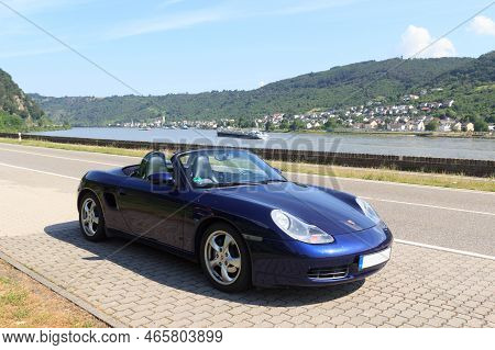 Bad Salzig, Germany - June 26, 2021: Blue Roadster Porsche Boxster 986 With River Rhine Gorge Panora