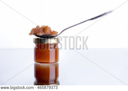 Jam In A Jar And A Spoon. Apple And Pear Jam In A Spoon On A White Mirror Background. Healthy Natura