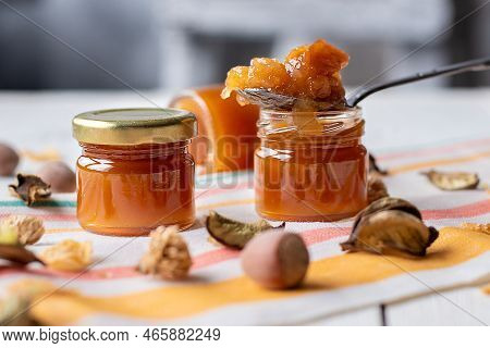 Jam In A Jar And A Spoon. Apple And Pear Jam In A Spoon On A White Mirror Background. Healthy Natura