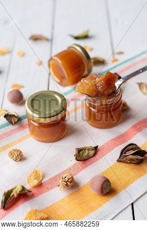 Jam In A Jar And A Spoon. Apple And Pear Jam In A Spoon On A White Mirror Background. Healthy Natura