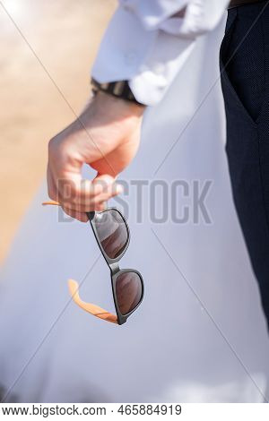 Bride's Hands On The Grooms Boutonniere. Wedding Decor For The Wedding Ceremony Of Flowers For Event