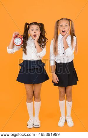 School Time. Surprised Shocked Kids Hold Alarm Clock Counting Time. Latecomer Will Be Punished. It I
