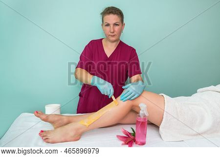 Leg Sugaring. A Beautician Makes A Sugar Paste Depilation Of A Woman's Legs In A Beauty Salon. Femal