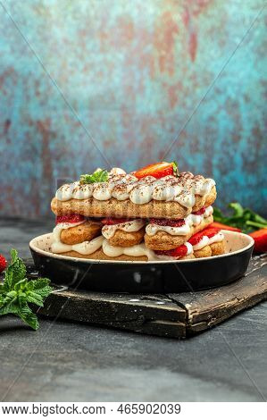 Homemade Tiramisu Cake With Fresh Strawberry, Mascarpone And Mint. Tiramisu Portion On Plate On Ligh