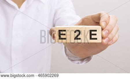 Hand Holding Wood Cubes With E2e Text. Financial, Management, Economic, Business Concept.