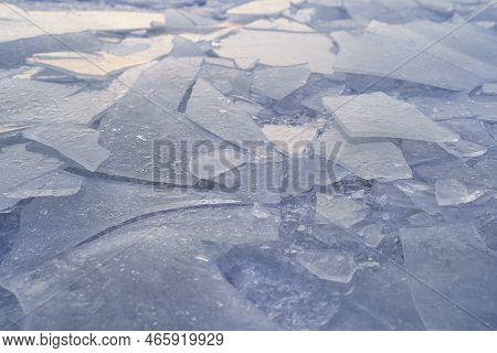 Close Up Of Ice Cracks On Frozen Lake In Winter. Layer Of Freezing Water On Top Of River. Ice-covere