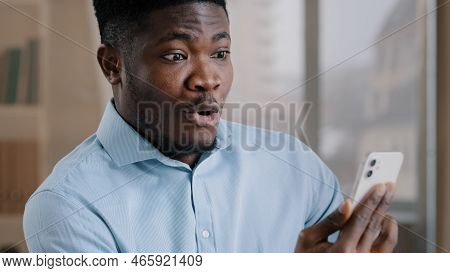 African Male Surprised Amazed Millennial 30s Man Worker Talking Remote On Mobile Phone Handsome Amer