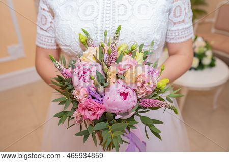 Bridal Bouquet Beautiful Of Pink Wedding Flowers In Hands Of The Bride. Close-up Interior Studio Sho