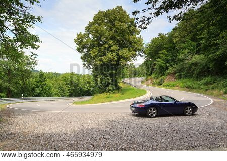 Hunsrueck, Germany - June 26, 2021: Blue Roadster Porsche Boxster 986 At Street With Hairpin Turn In