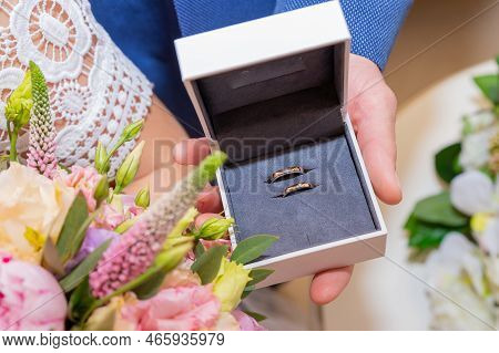 Golden Wedding Rings On Bridal Bouquet With Fresh Flowers: Rice Flower, Pink Peonies, Eustoma. Marri