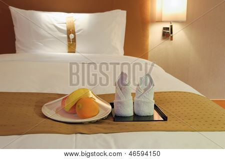 Handtücher und Obst auf dem Bett In einem Hotelzimmer