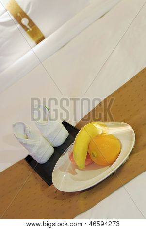 Handtücher und Obst auf dem Bett In einem Hotelzimmer