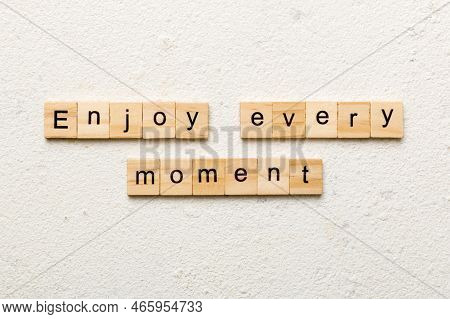 Enjoy Every Moment Word Written On Wood Block. Enjoy Every Moment Text On Cement Table For Your Desi