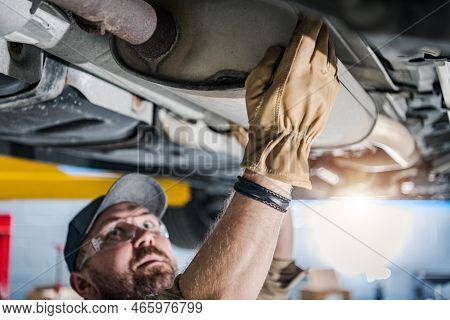 Closeup Of Car Catalytic Converter Being Checked By Professional Mechanic At Vehicle Repair Station.