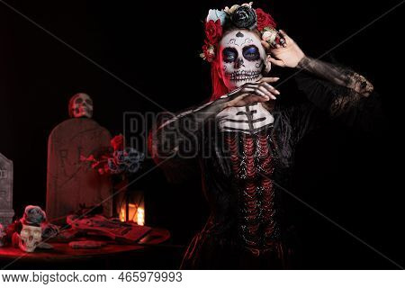 Creepy Woman Posing As Lady Of Death With Flowers Wreath And Skull Make Up, Wearing Santa Muerte Bla