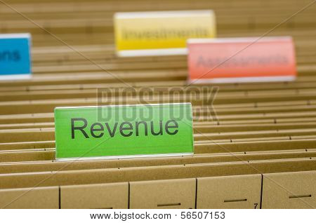 A hanging file folder labeled with Revenue