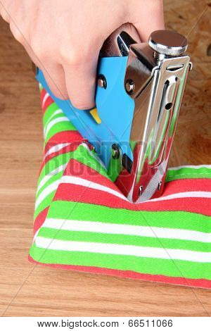 Fastening fabric and board using construction stapler