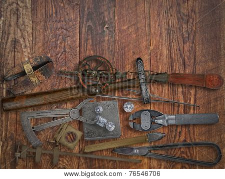 vintage jeweler tools and diamonds over wooden working bench, space for text