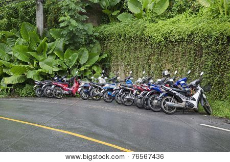 Phuket,TH-Sept,15 2014:Motorbikes stand in a row on wet road in Sept, 15 2014 in Phuket, Thailand