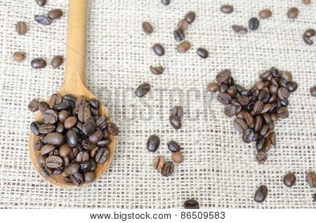Wooden Spoon Full With Roasted Coffee Beans And A Coffee Heart