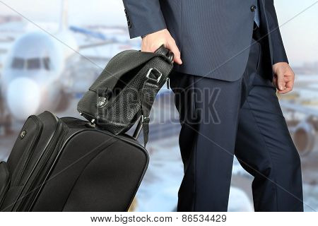Young Businessman  In  A Modern  Stylish Suit With  Luggage In  The Airport.