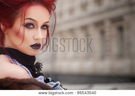 sexy woman with gothic makeup and red hair and castle