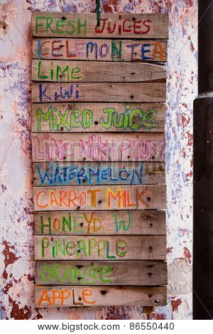 Assortment of soft drinks and juices in the decorative design of the sign of the small wooden boards.