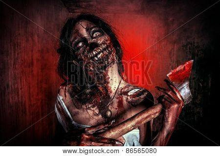 Scary bloody zombie girl with an ax. Halloween.