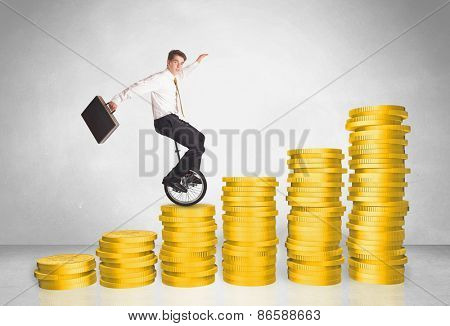 Business man riding monocycle up on coin graph concept on background