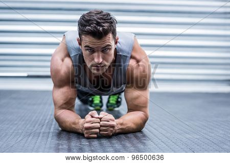 Portrait of a muscular man on plank position