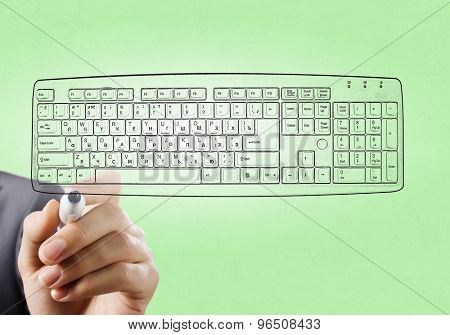 Close up of hand darwing computer keyboard with marker 