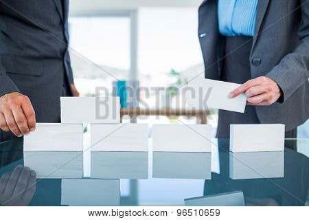 Business people stacking paper bloc in office