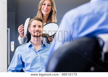Haircutter showing customer the new cut